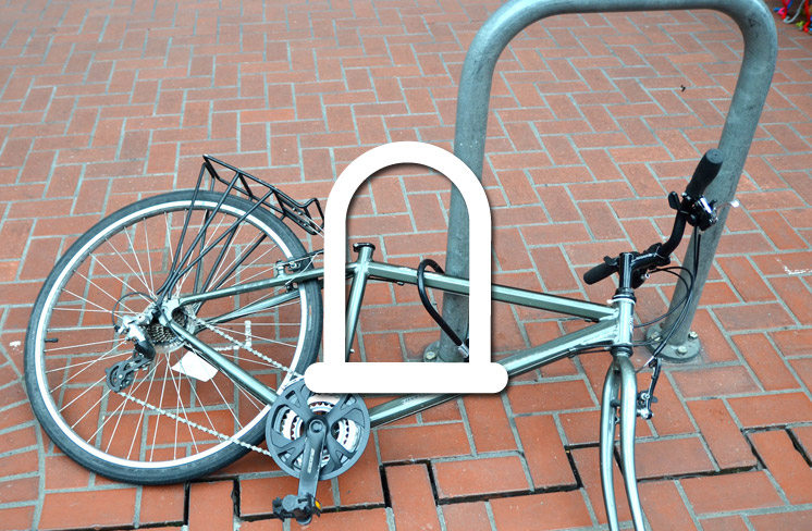 Photo of bike locked to bike rack with front wheel missing.