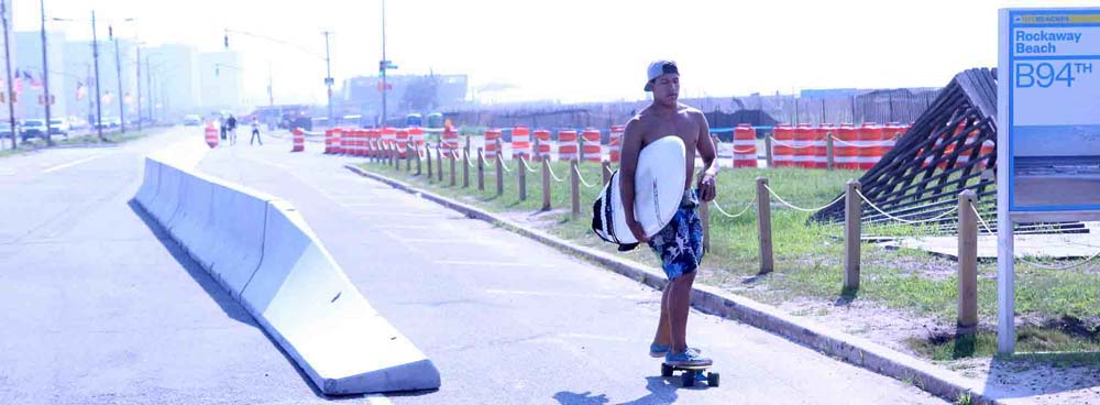 On his way to surf, a skater avails himself of a concrete safety barrier's protection from traffic along the Jamaica Bay Greenway. Image courtesy of the New York City Department of Transportation.