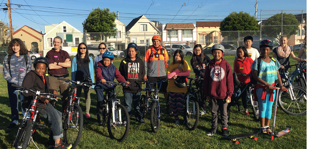 Physical Education teacher Shenny Diaz indicates that, for the Denman Middle School Bike Club, today was the first time 60 percent of them biked on-street.