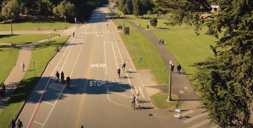 Aerial view of a car-free JFK Drive in Golden Gate Park showing people biking and walking in the street and on the sidewalk paths.