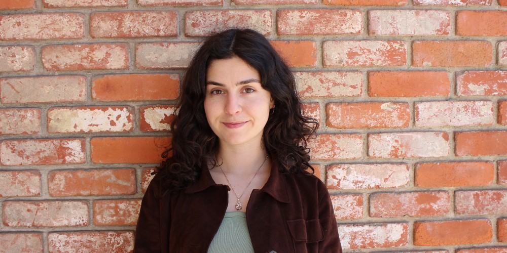 photo of person in front of brick wall