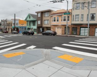 Photo of an SF intersection, showing two high-visibility crosswalks running the length of the street.