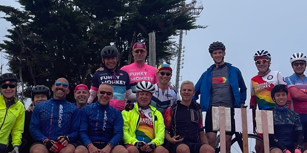 a group of people, some in helmets, standing together in front of a tree